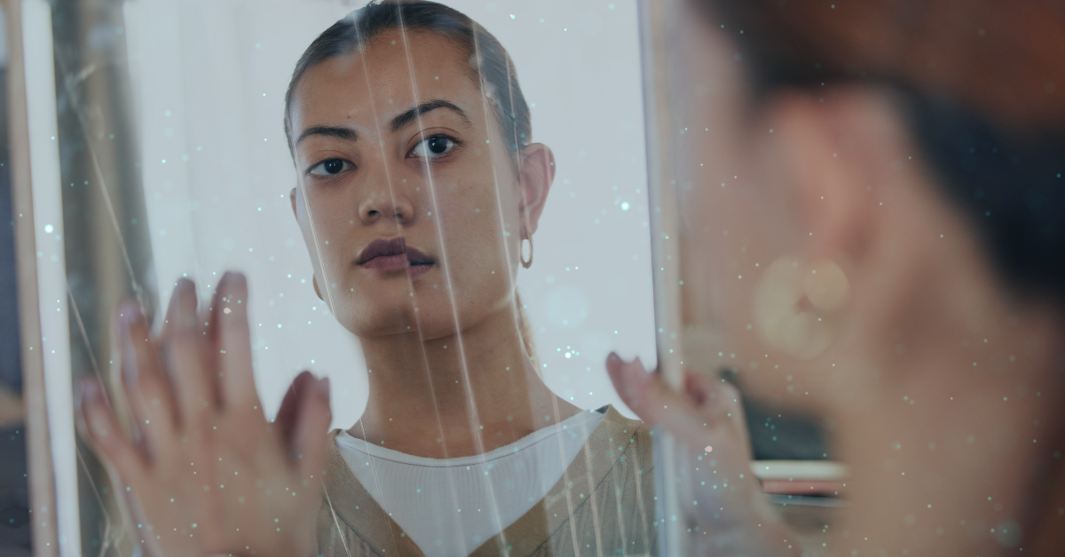 woman looking through a broken mirror