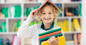 child with book on their head smiling