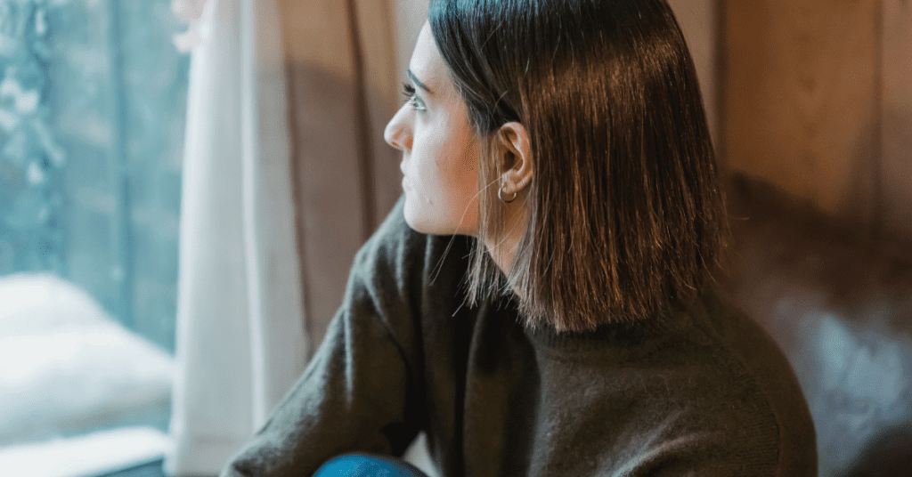 A person sitting on a couch looking out the window