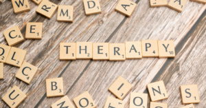 letter scrabble pieces that spell out the word 'therapy'