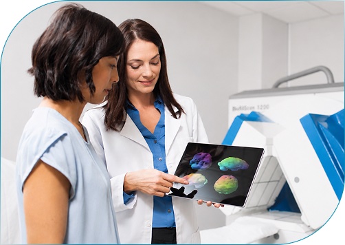 Physician and patient reviewing brain scans on a tablet next to the MultiView SPECT imaging system