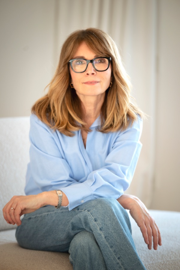 Woman wearing glasses sitting comfortably and looking at the camera
